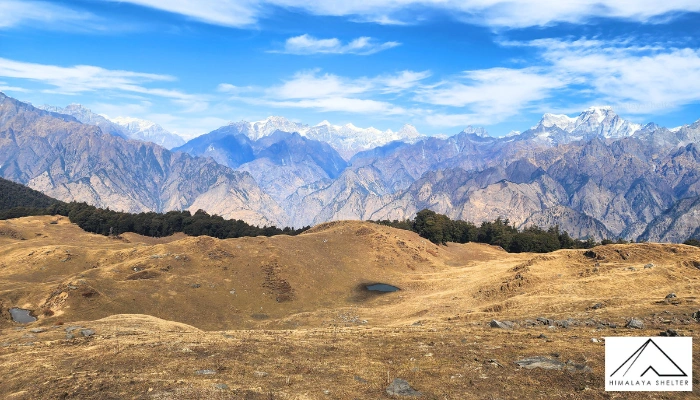 Walking across Kuari Pass’s rolling alpine meadows towards the snow-clad peaks